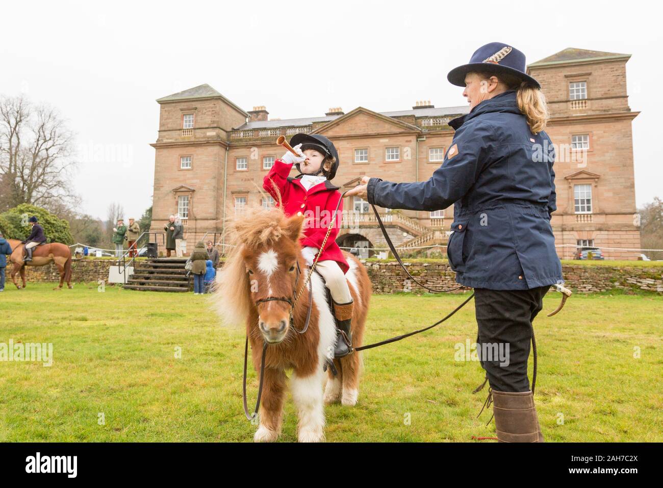 Hagley, Worcestershire, UK. 26th December 2019. 6-year-old Henley Mills blows his horn on his pony Radish as the Albrighton and Woodland Hunt gathers at Hagley Hall on Boxing Day for its traditional annual meet. Peter Lopeman/Alamy Live News Stock Photo