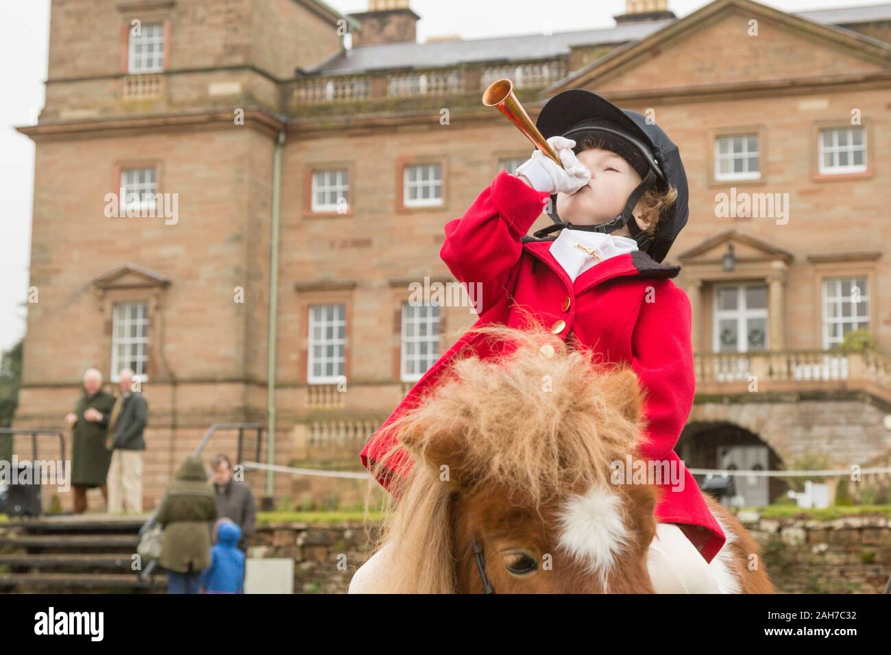 Hagley, Worcestershire, UK. 26th December 2019. 6-year-old Henley Mills blows his horn on his pony Radish as the Albrighton and Woodland Hunt gathers at Hagley Hall on Boxing Day for its traditional annual meet. Peter Lopeman/Alamy Live News Stock Photo