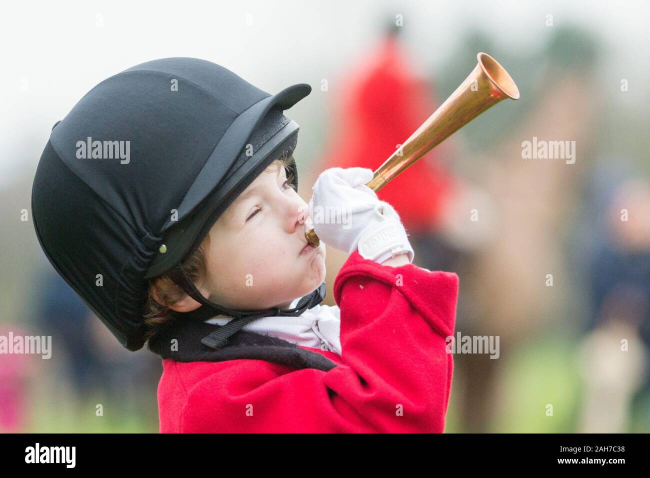 Hagley, Worcestershire, UK. 26th December 2019. 6-year-old Henley Mills blows his horn on his pony Radish as the Albrighton and Woodland Hunt gathers at Hagley Hall on Boxing Day for its traditional annual meet. Peter Lopeman/Alamy Live News Stock Photo