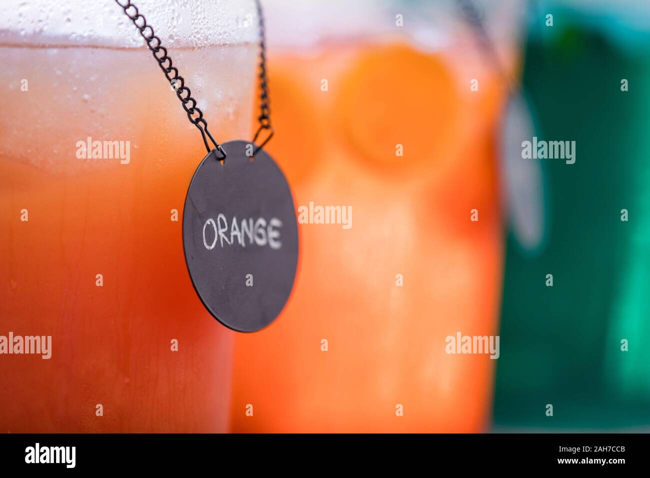 Close up of two jugs of juice, orange in the foreground and mint in the background Stock Photo