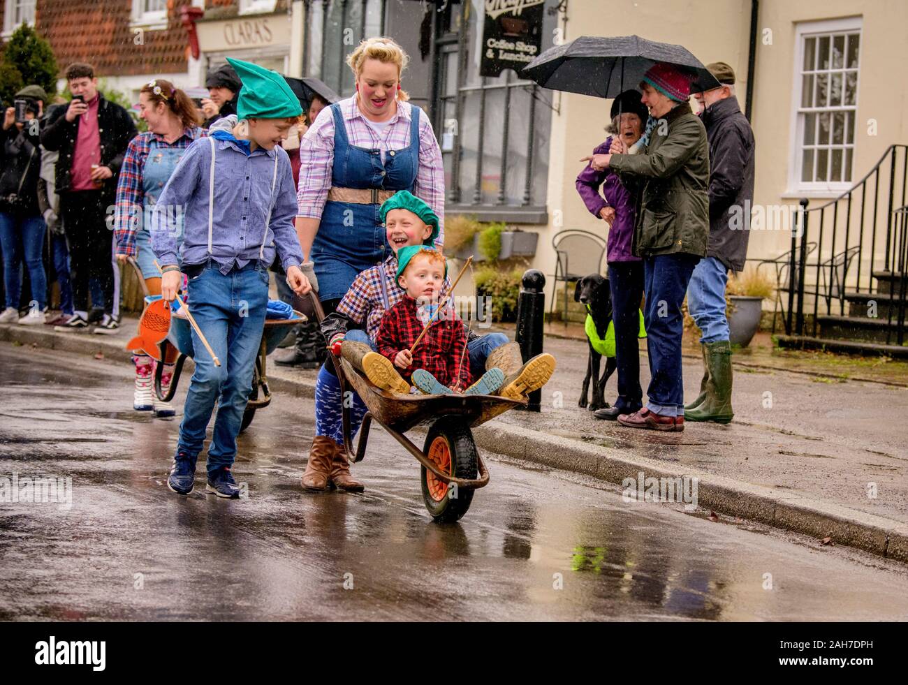 East Hoathly, UK. 26 December, 2019.  Villagers compete in their annual Boxing Day Pram Race through the rainy streets of East Hoathly, East Sussex, UK. The wacky racers build their machines in secret each year before racing their creations to the Kings Head pub. Credit:  Jim Holden/Alamy Live News. Stock Photo