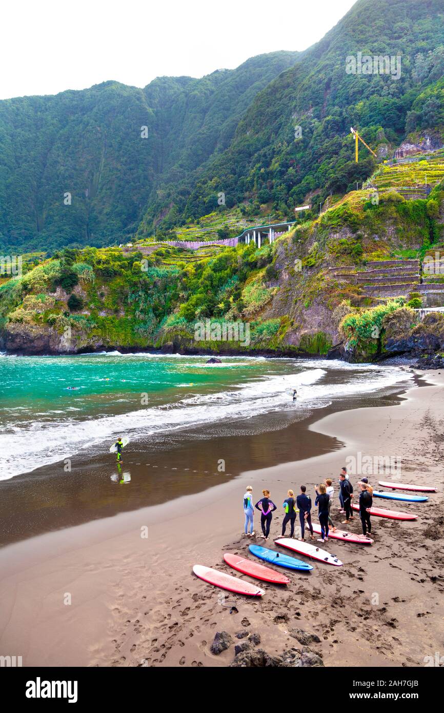 A group of people with surfboards standing on a beach doing a surfing class, Seixal, Madeira, Portugal Stock Photo