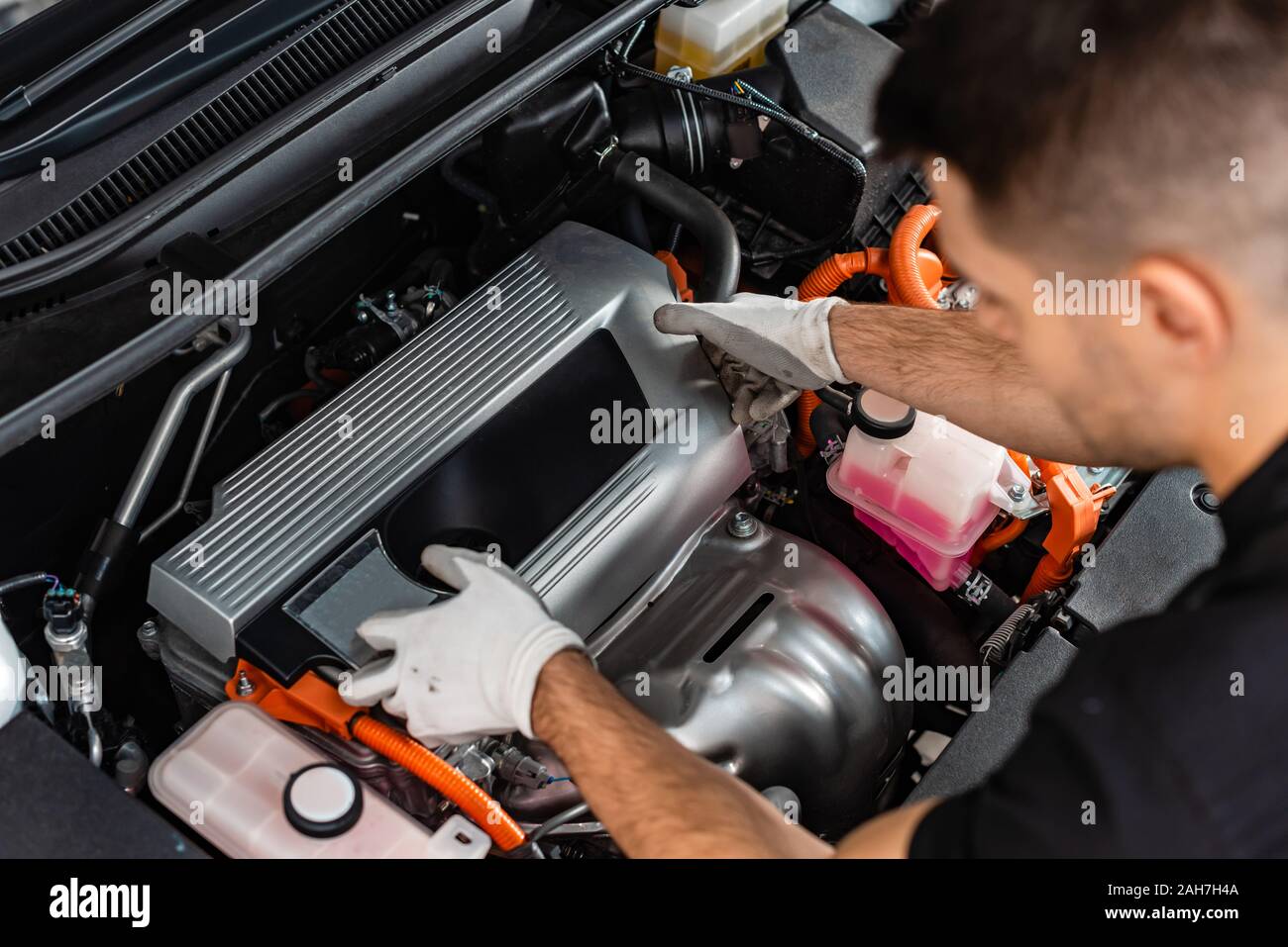 overhead view of young mechanic inspecting car engine compartment Stock
