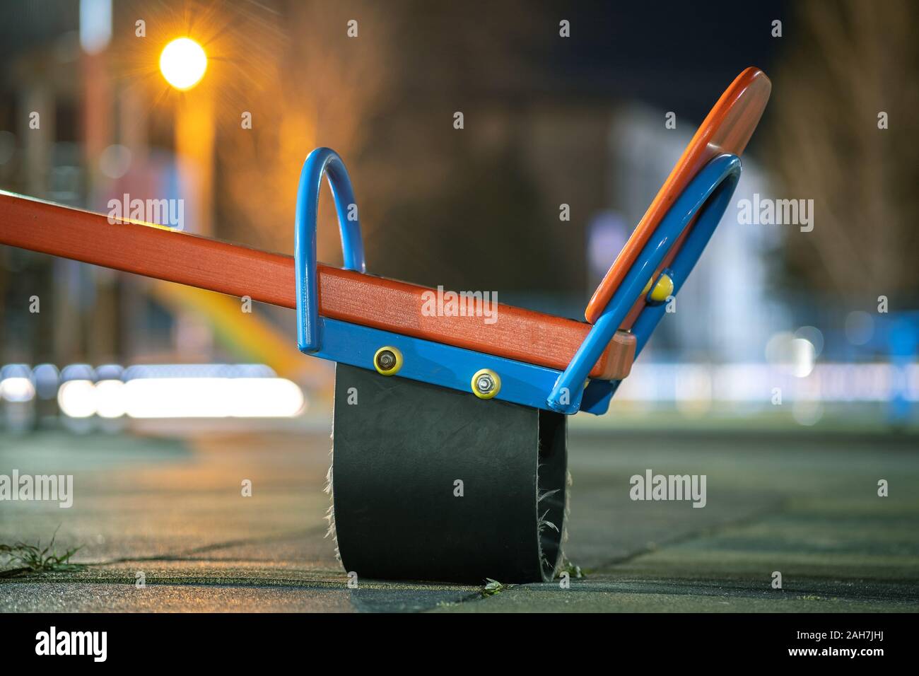 Seesaw swing in preschool yard with soft rubber flooring at night. Stock Photo