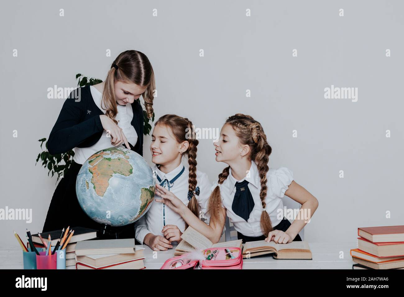 three girls in the school geography lesson learn globe knowledge Stock ...