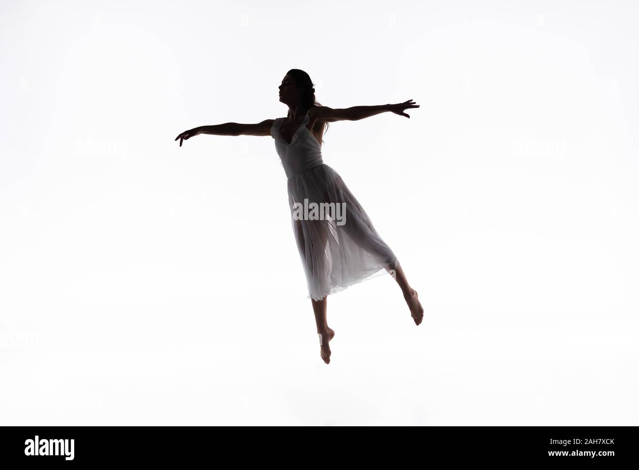 Young Graceful Ballerina Jumping While Dancing On White Background