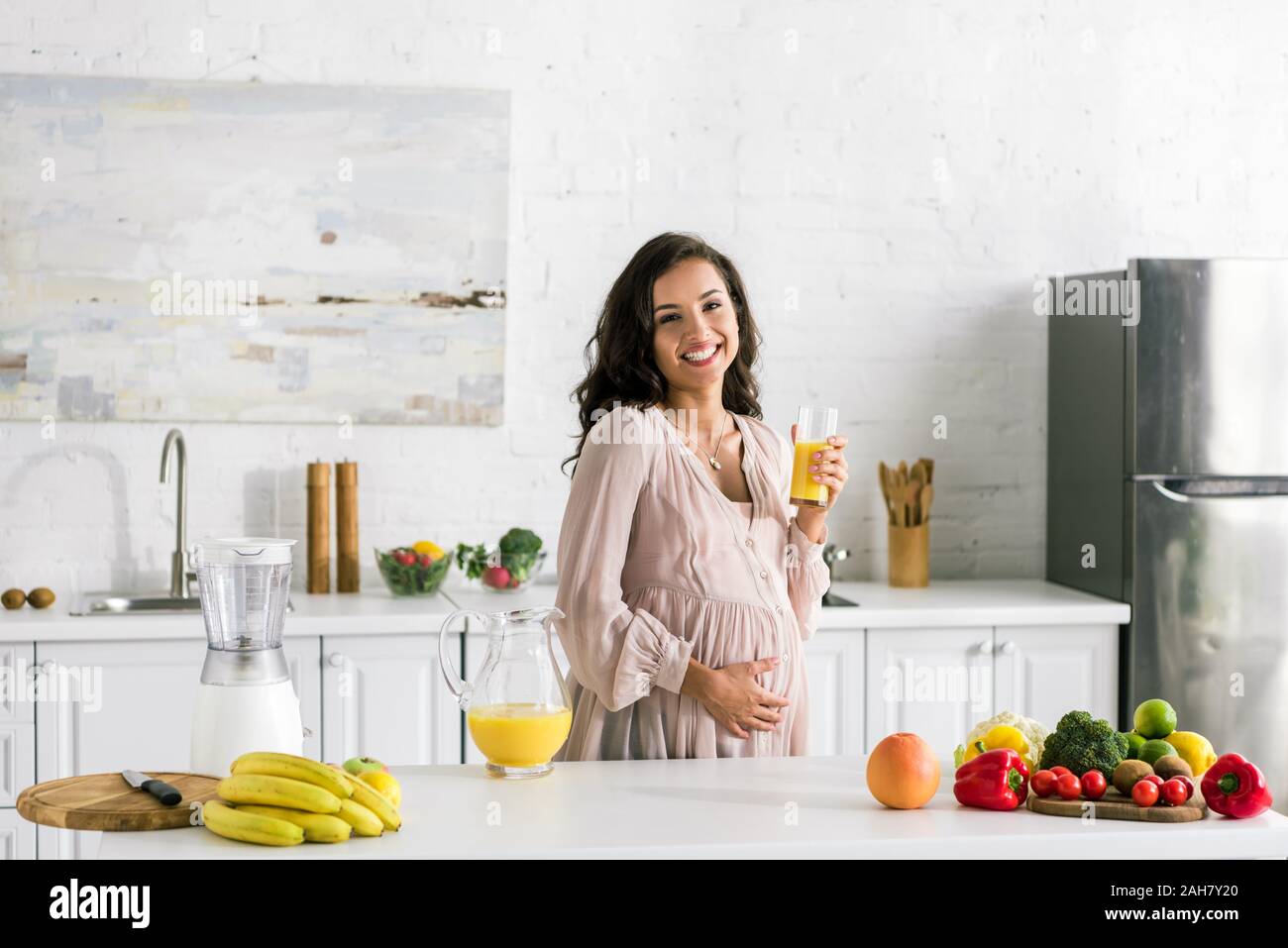 happy pregnant woman holding glass with fresh orange juice Stock Photo ...