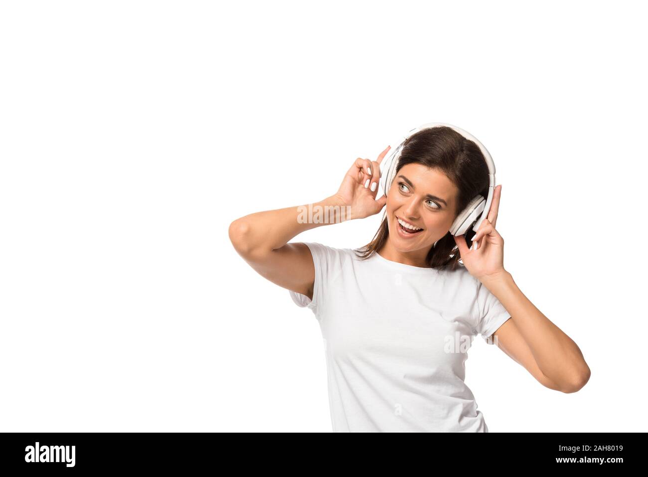 cheerful young woman listening music with headphones, isolated on white ...