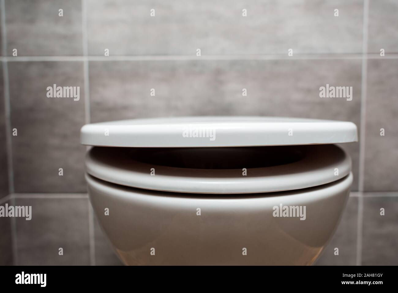 close up view of ceramic clean toilet bowl with lid in modern restroom ...