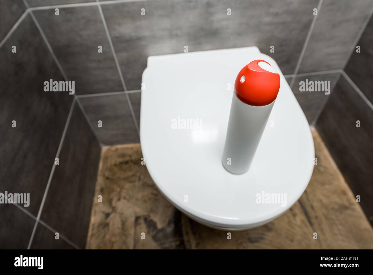 air freshener in spray bottle on ceramic clean toilet bowl in modern
