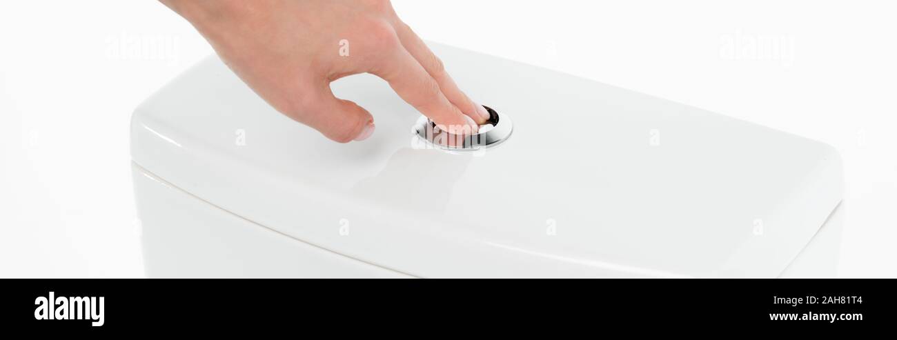copped view of woman pushing flushing button on ceramic clean toilet bowl isolated on white, panoramic shot Stock Photo