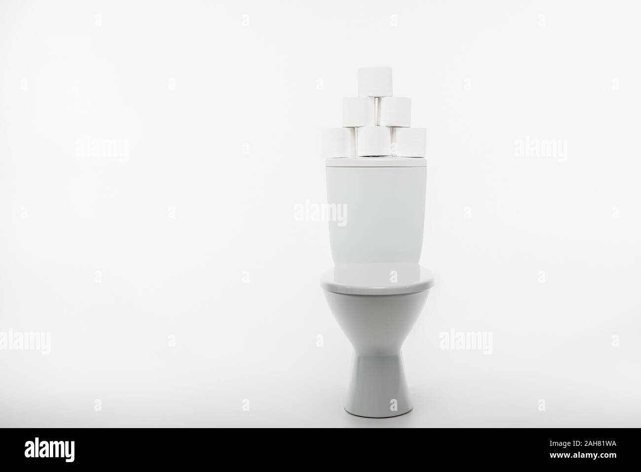 ceramic clean toilet bowl with rolls of toilet paper on white ...