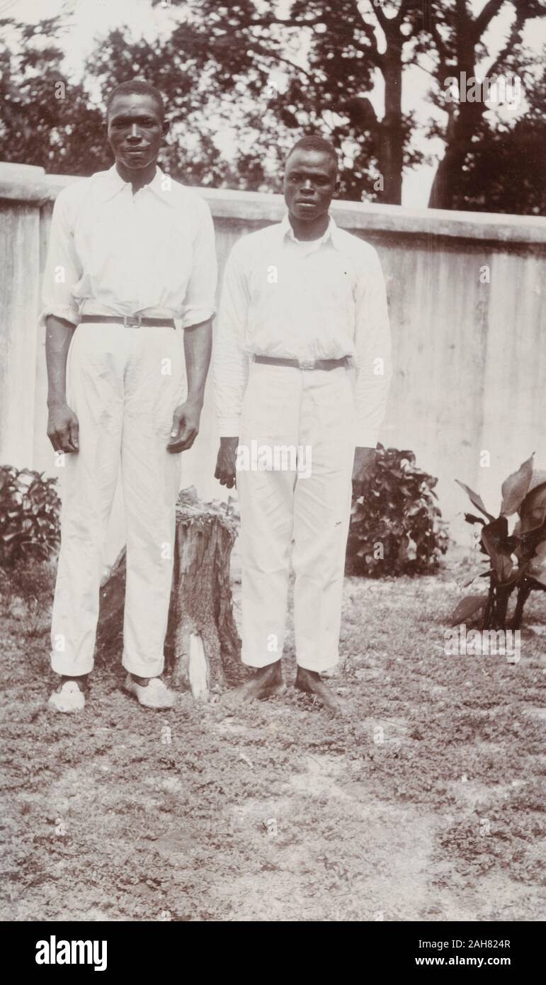 Nigeria, Caption reads: 'Joe (cook) and Sam (steward). House staff 1928'. Portrait of two male domestic servants, 'Joe' a cook and 'Sam' a steward, in a garden, 1928. 2000/098/1/106. Stock Photo