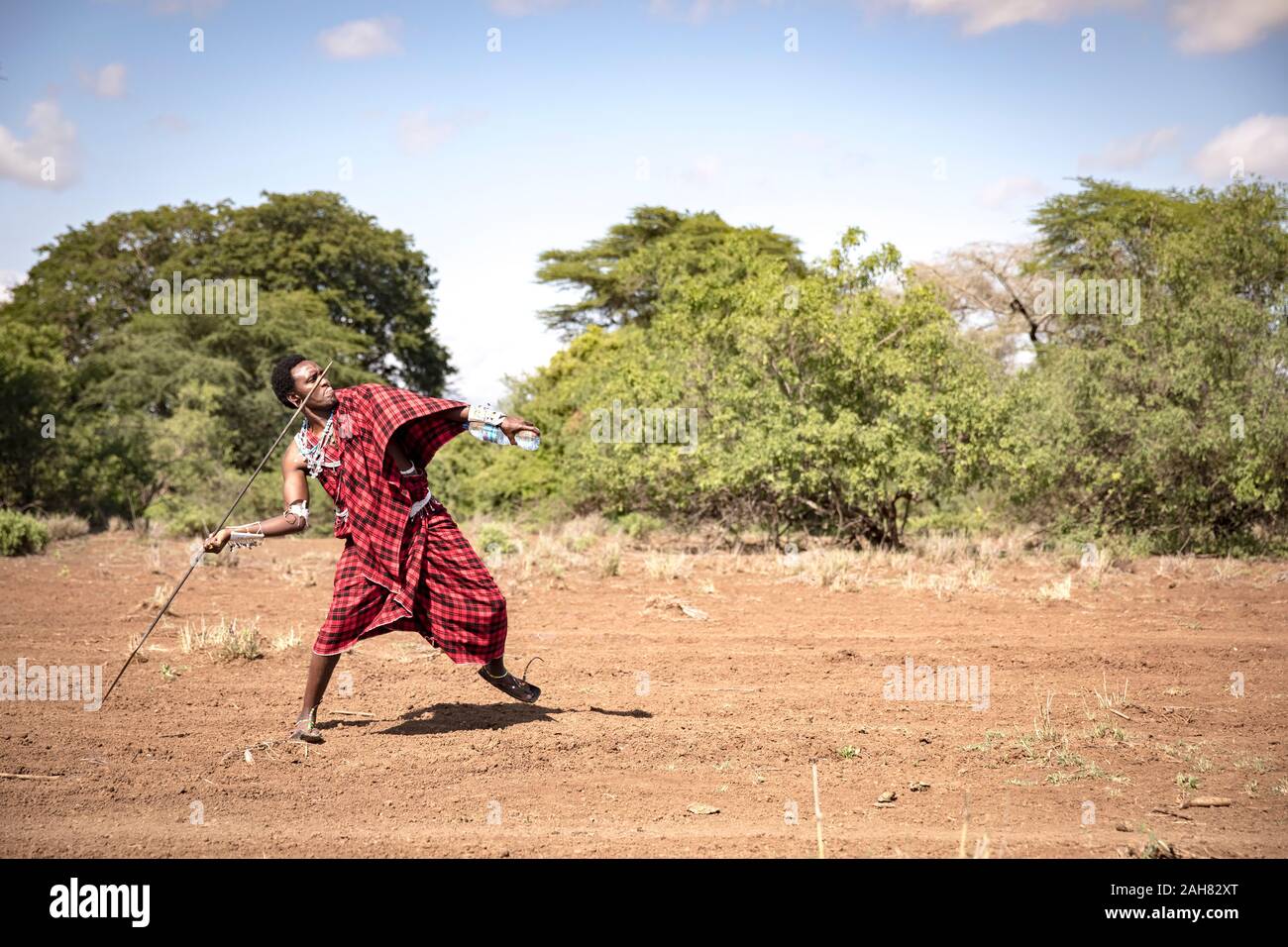 handsome maasai warrior throwing his spear Stock Photo