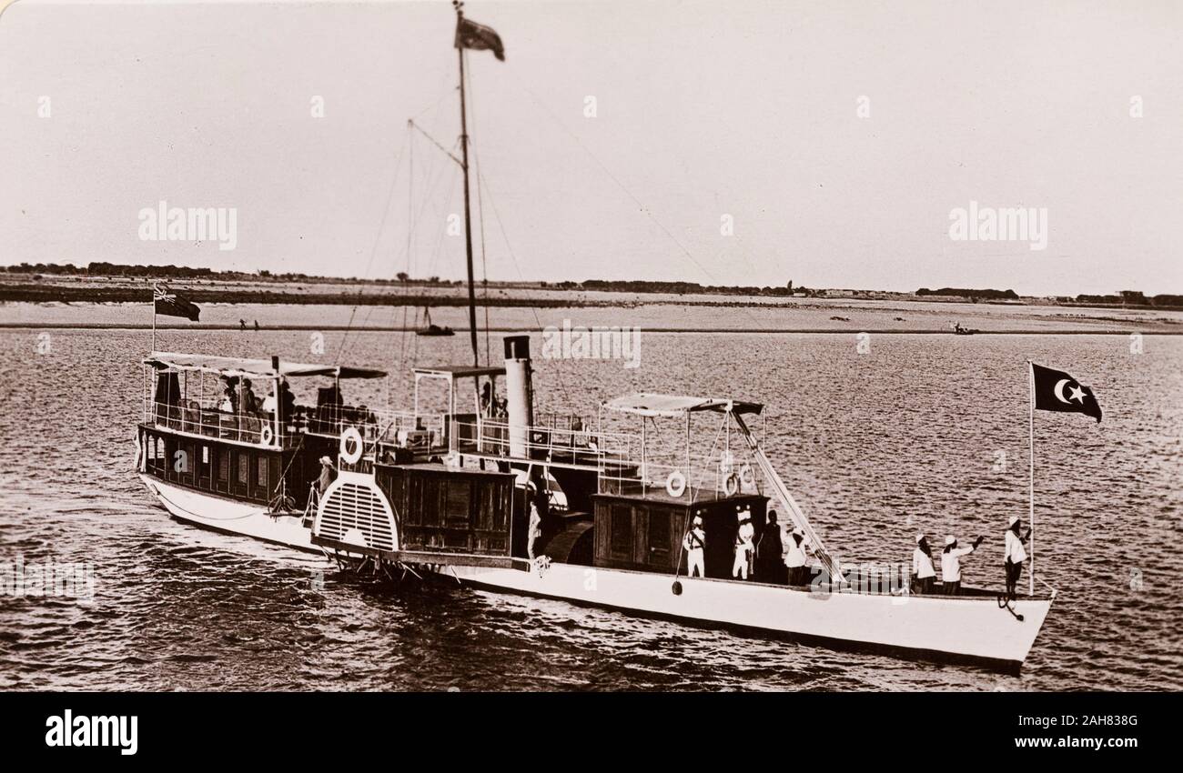 Sudan, Printed caption reads: 'The Governor's Boat (the 'Elfin') in the Blue Nile. Published by G N Morhig, The English Pharmacy, Khartoum. Copyright 17'. A paddle steamer named 'The Elfin' travels along the River Nile, flying a British Empire flag at its stern and a Ottoman Empire flag at its bow, [c.1906]. 2003/222/1/2/82. Stock Photo