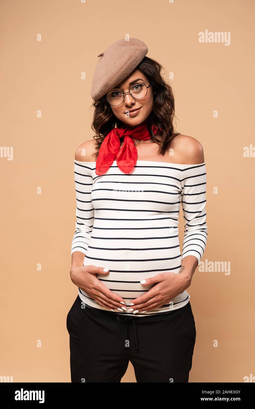 Pregnant French Woman In Beret Looking At Camera On Beige Background Stock Photo Alamy