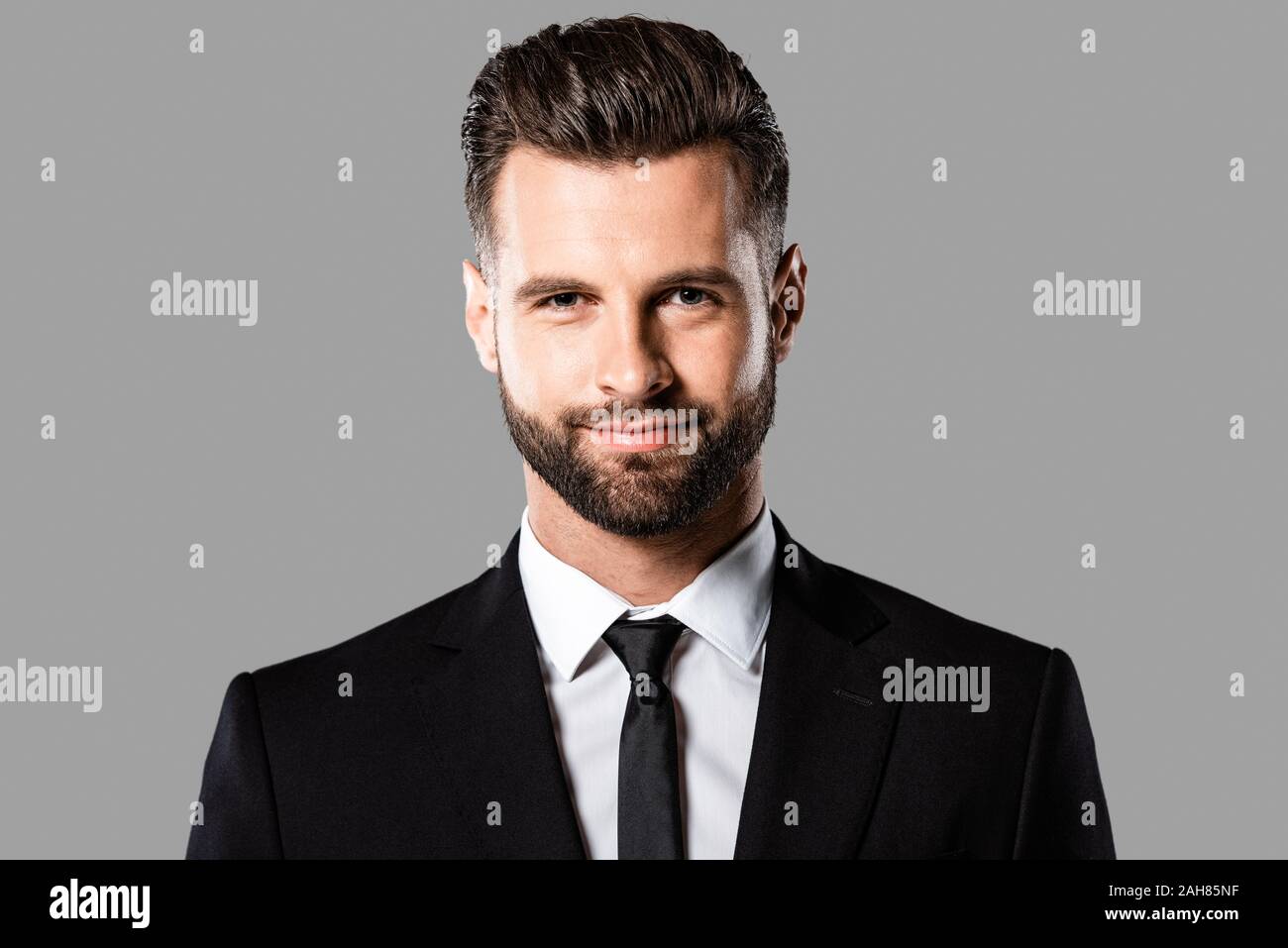 smiling handsome businessman in black suit isolated on grey Stock Photo ...
