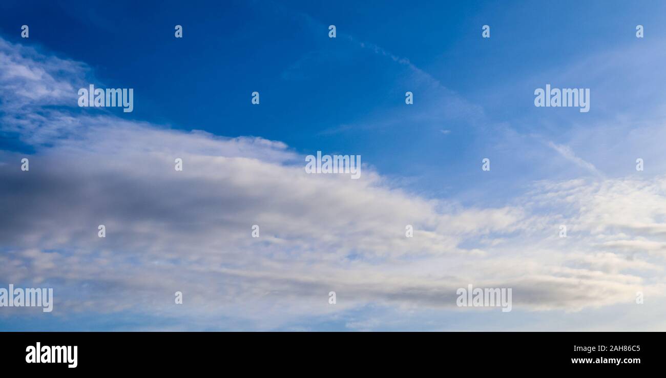 Beautiful and warm orange sunset clouds on a deep blue sky Stock Photo ...