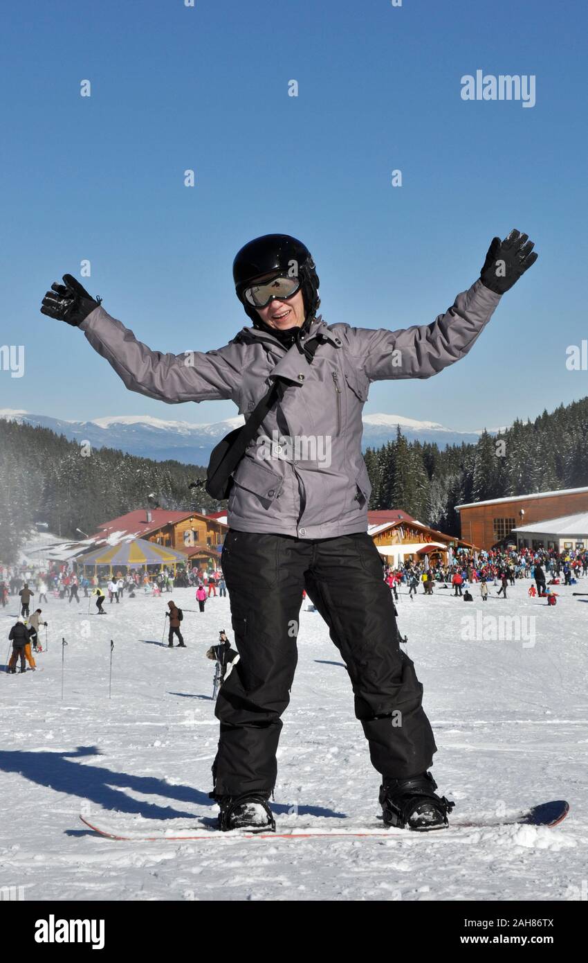 Bansko ski skiing and snowboarding Female snowboarder posing happily on sunny day in Bansko