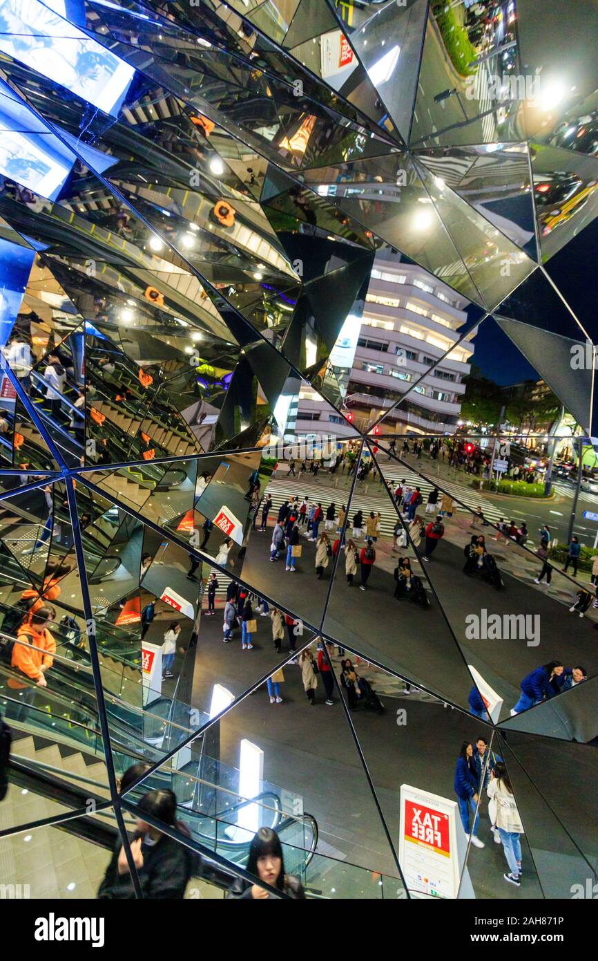 Hall of Mirrors entrance at the Tokyu Plaza building in Omotesando, Tokyo. Reflections of the escalators and street with pedestrian crossing. Night. Stock Photo