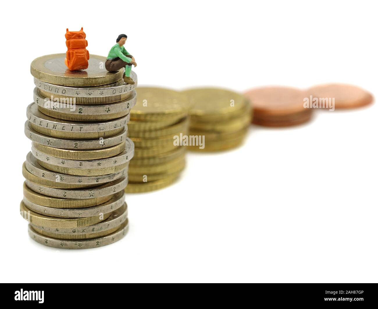 Miniature hiker sits on stack of euro coins, concept of financial independence, a long way to success Stock Photo