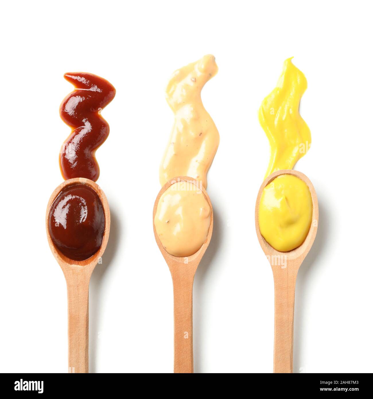 Wooden spoons with sauces isolated on white background Stock Photo