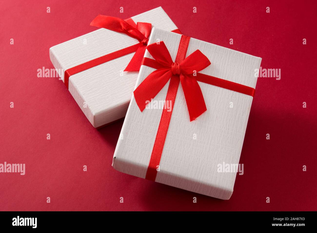 Assorted white gift boxes on red background. Stock Photo