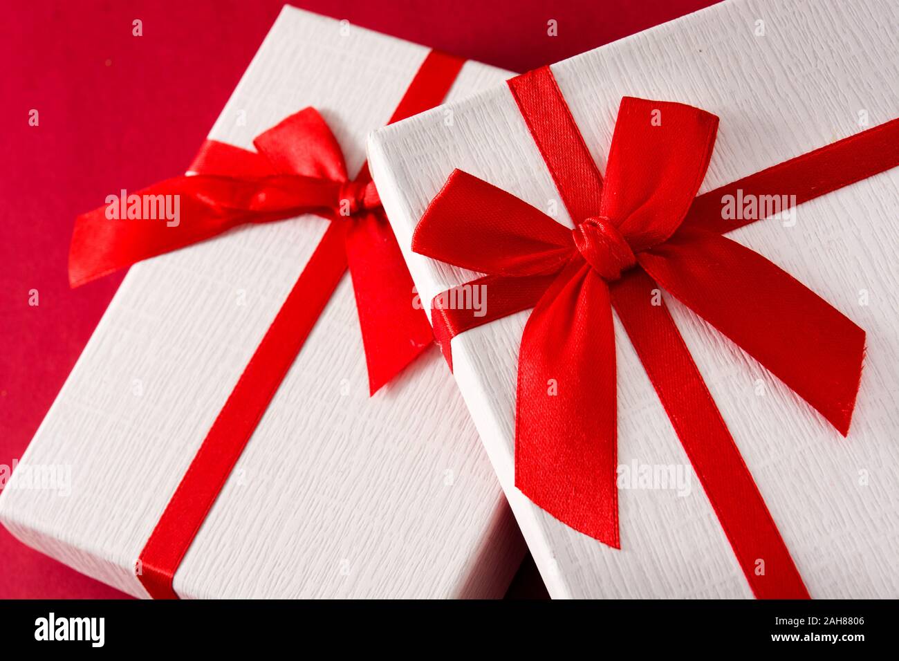 Assorted white gift boxes on red background. Stock Photo