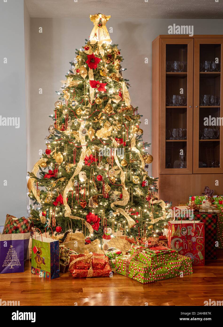 Interior of modern home with christmas tree decorated and illuminated and wrapped presents and gifts under the tree Stock Photo