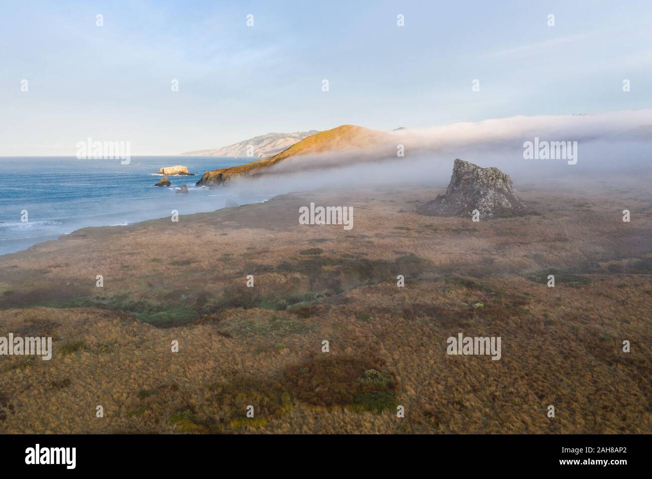 Morning mist flows over the rugged landscape of northern California in