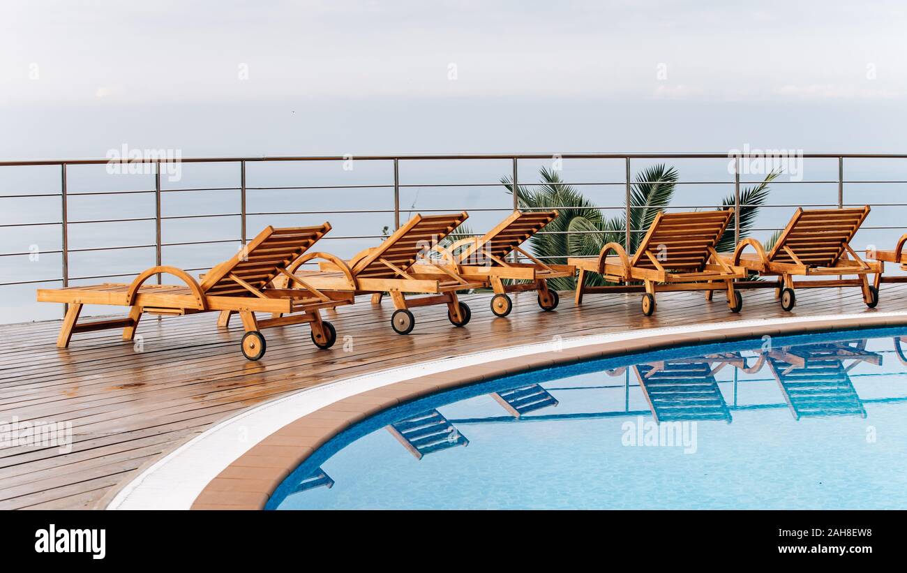 Wooden deck chairs in the hotel with scenic views of the ocean or sea ...
