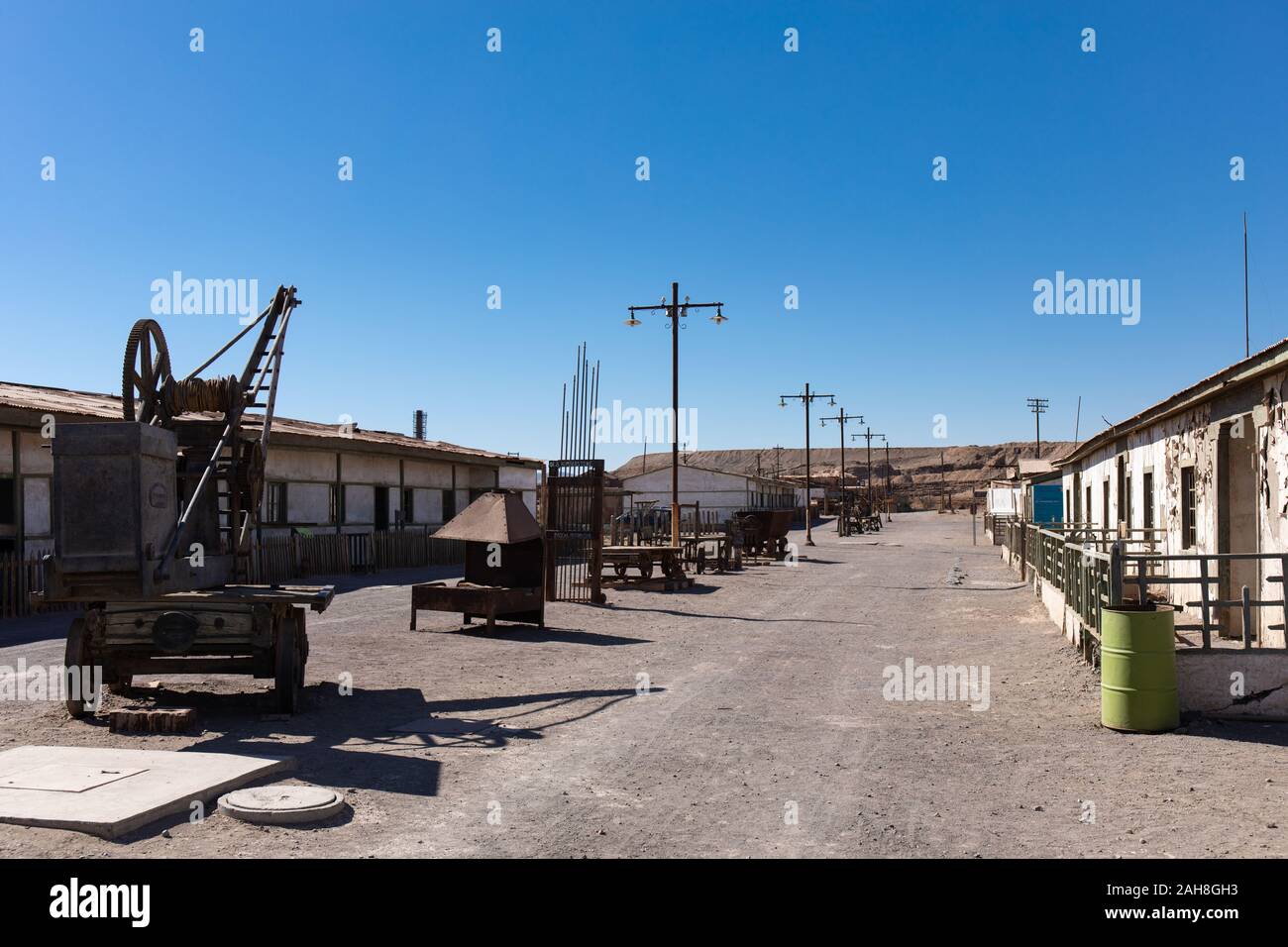 Machinery on display in a street in the residential area of the abandoned Humberstone Saltpeter factory in the Atacama Desert, Northern Chile Stock Photo