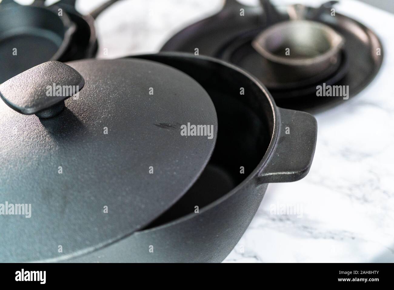 Variety of cast iron frying pans on a marble background Stock Photo Alamy