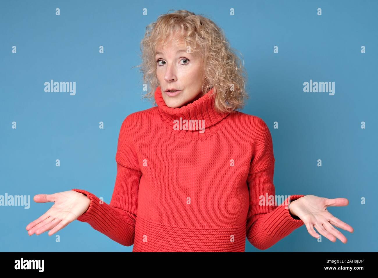 Woman throws up hands shrugging her shoulders being unsure having some