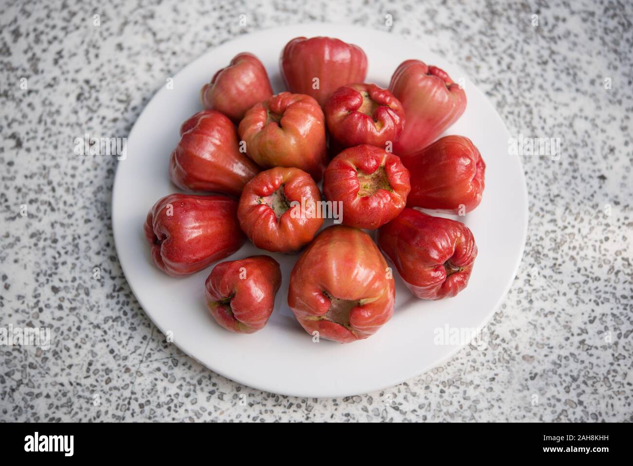 Wax apples (Syzygium samarangense) on a plate. Aka Java apple, rose apple, wax jambu. A tropical fruit popular in Southeast Asia. Stock Photo