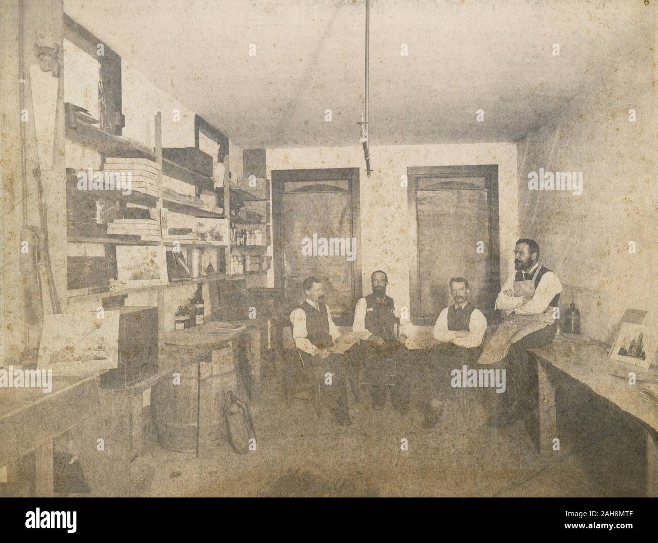 Antique c1890 photograph, photographers in a storage room with paper and bottles of chemicals on the shelves in Binghamton, New York. SOURCE: ORIGINAL PHOTOGRAPH Stock Photo