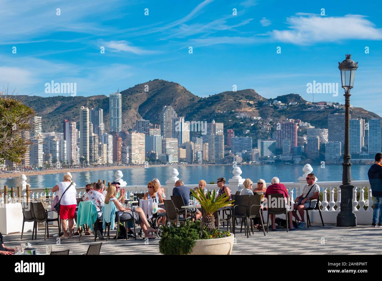 Benidorm, Costa Blanca, Spain,  tourists on the Balcon enjoying the winter sun with a view of Levante Beach in the background. Stock Photo