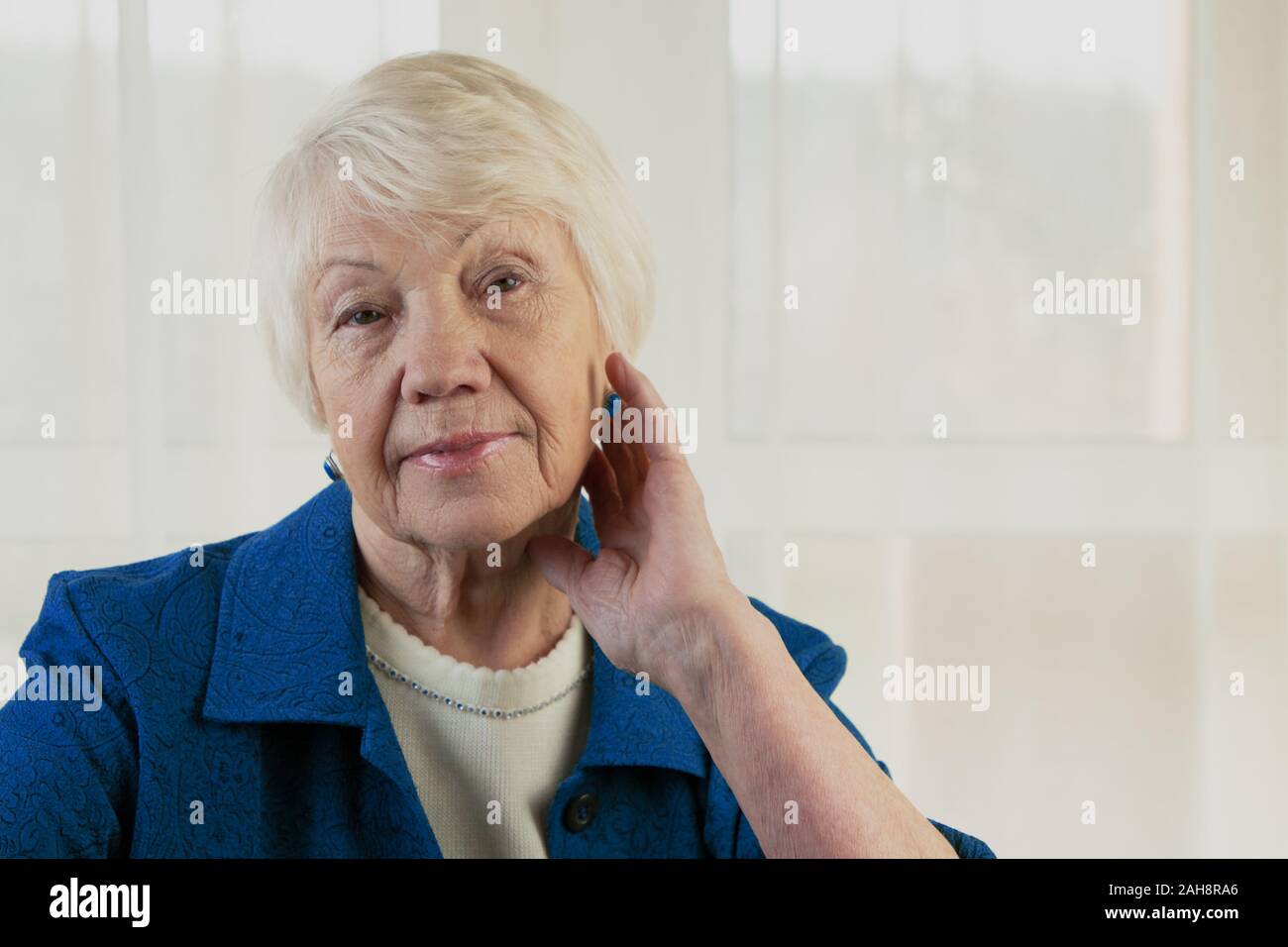 Beautiful senior woman looking at the camera with a warm friendly smile and attentive expression Stock Photo