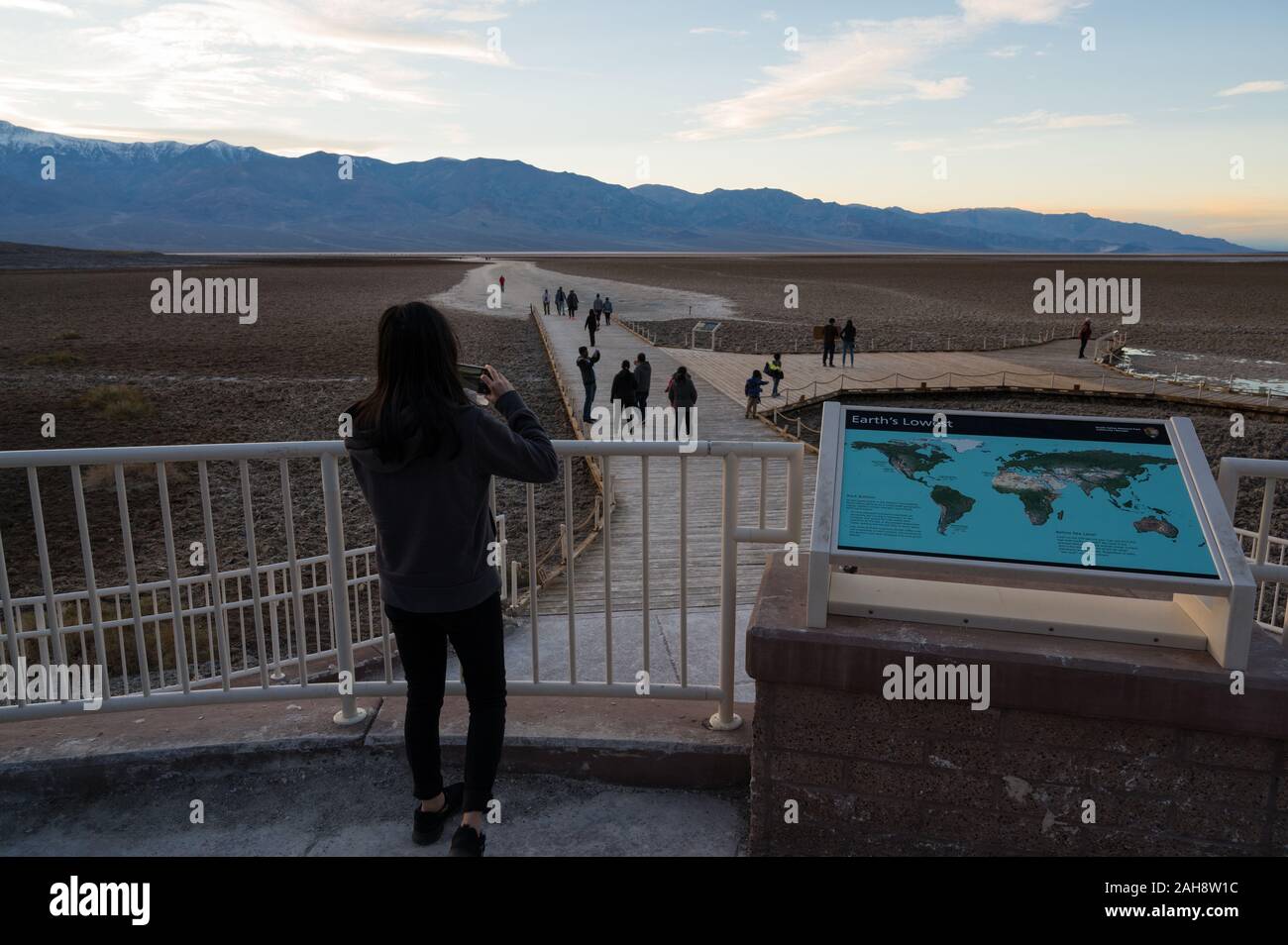 Woman taking a photo of the path leading into Badwater Basin in Death ...