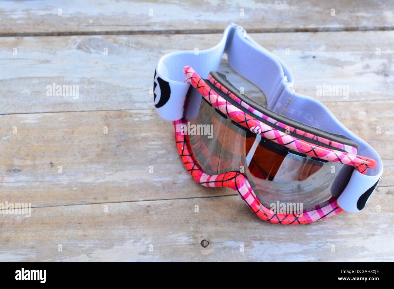 Red ski googles left on white, grunge wooden table Stock Photo