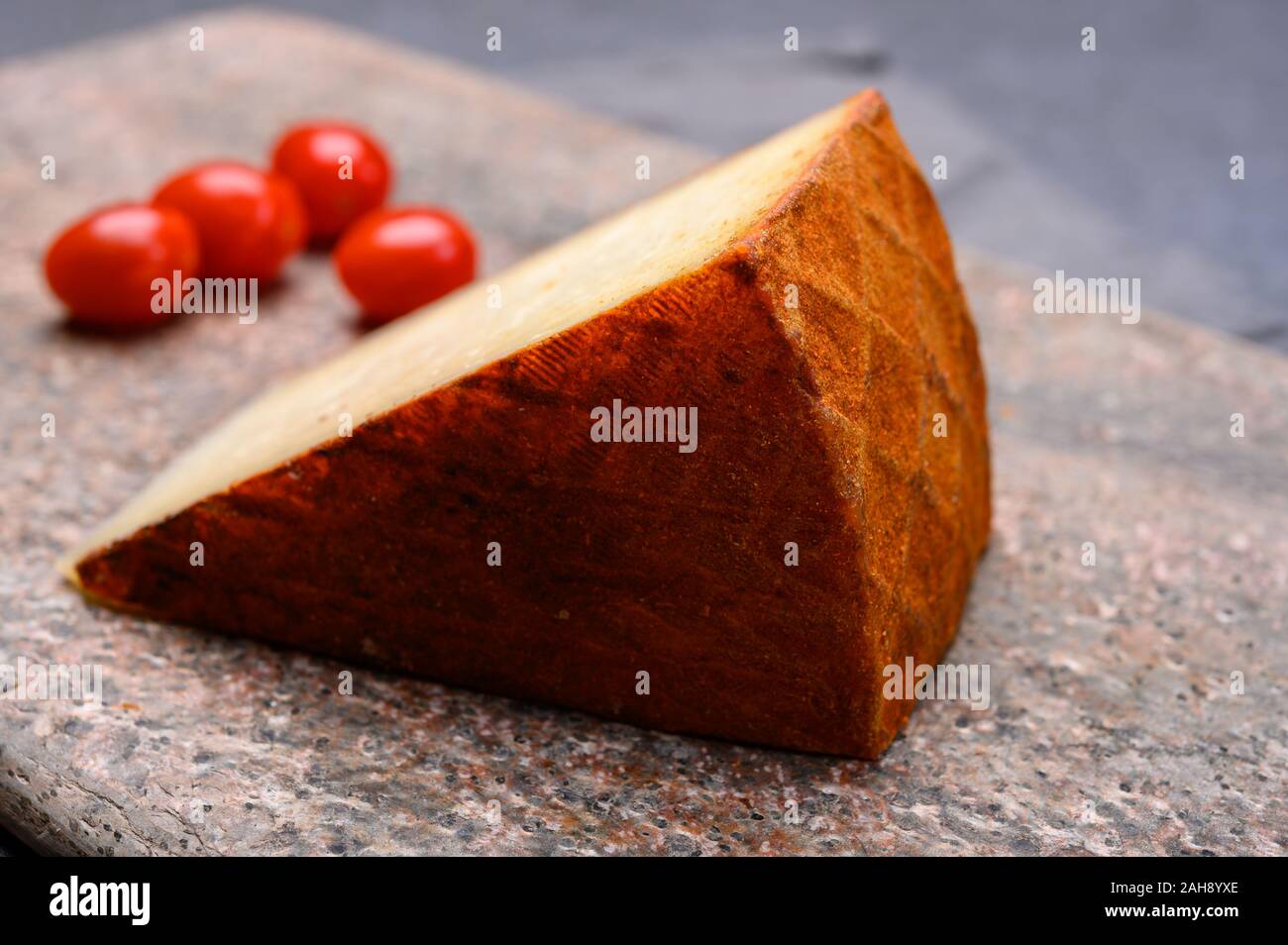 Cheese collection, piece of Spanish manchego cheese made from cow milk with red paprika close up