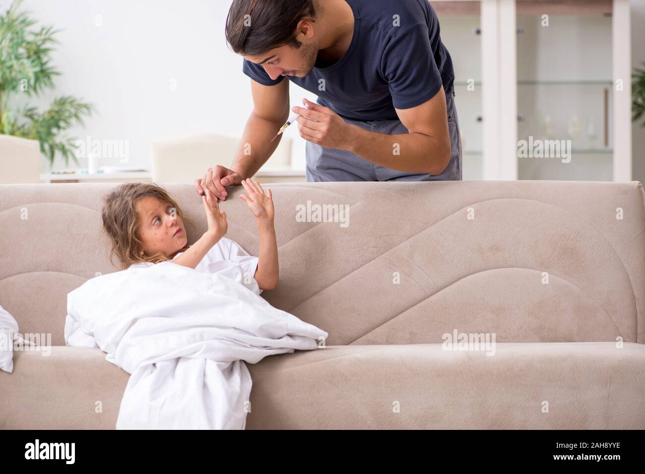 The father taking care of his ill daughter Stock Photo