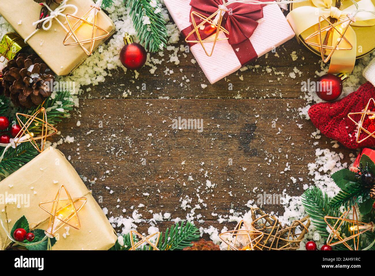 Holiday Christmas card background with festive decoration ball, stars, snowflakes, gift box, pine cones on a wood background from Flat lay, top view. Stock Photo