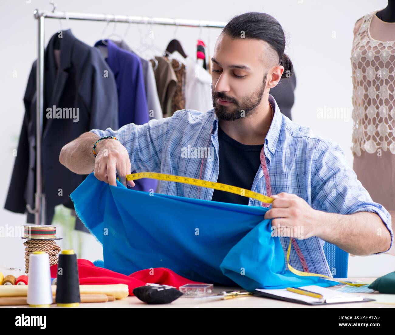 The male tailor working in the workshop on new designs Stock Photo - Alamy