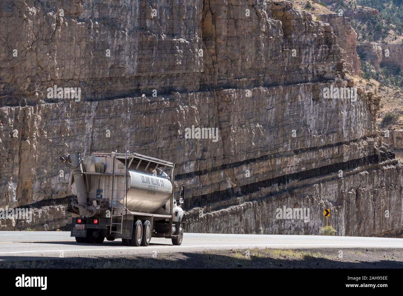 Truck driving through a road cut with coal seams on Highway 6 in Carbon County, Utah. Stock Photo