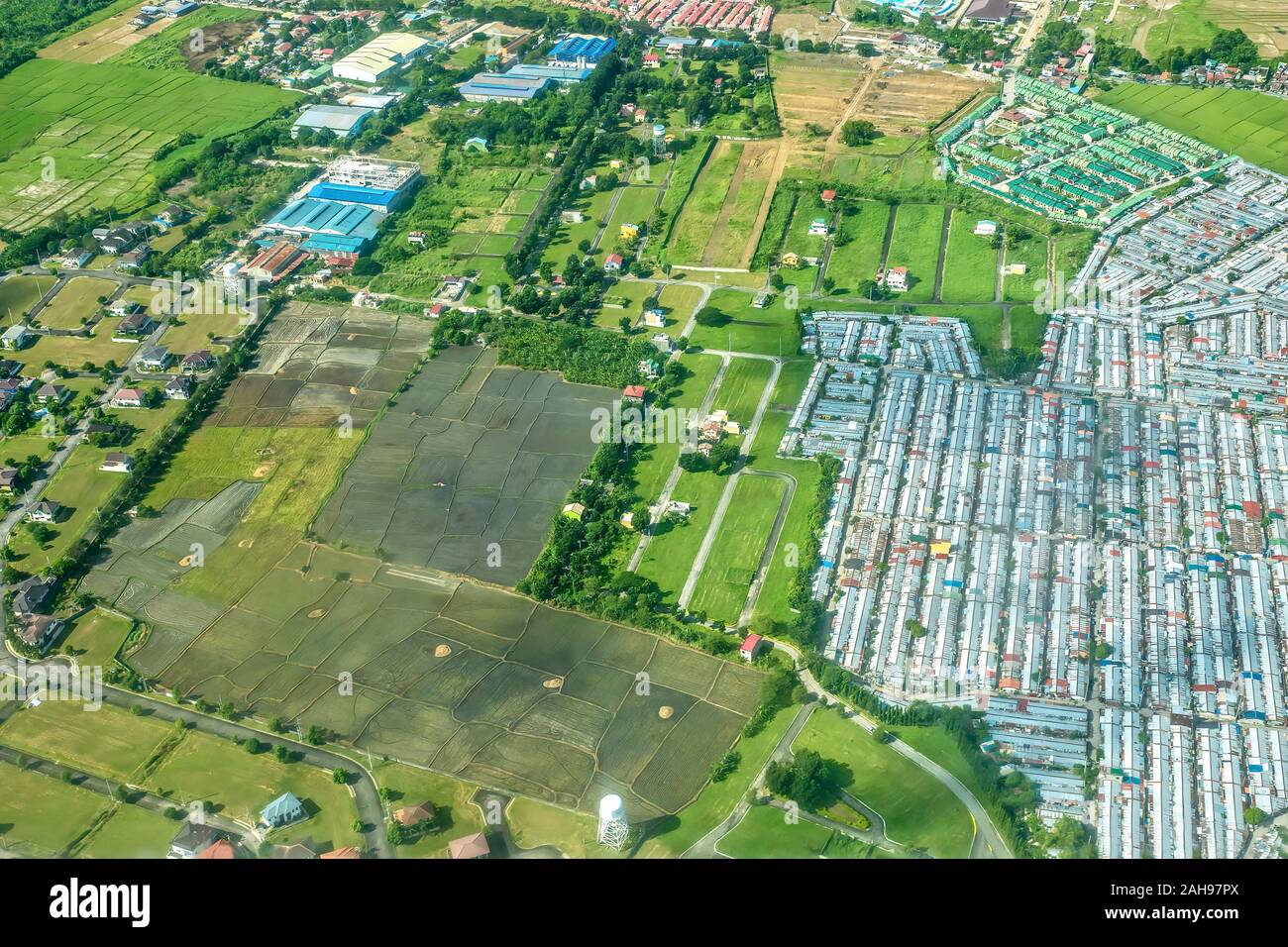 Aerial view showing dense urban expansion due to high population growth into agricultural farm land on Luzon island in the Philippines. Stock Photo