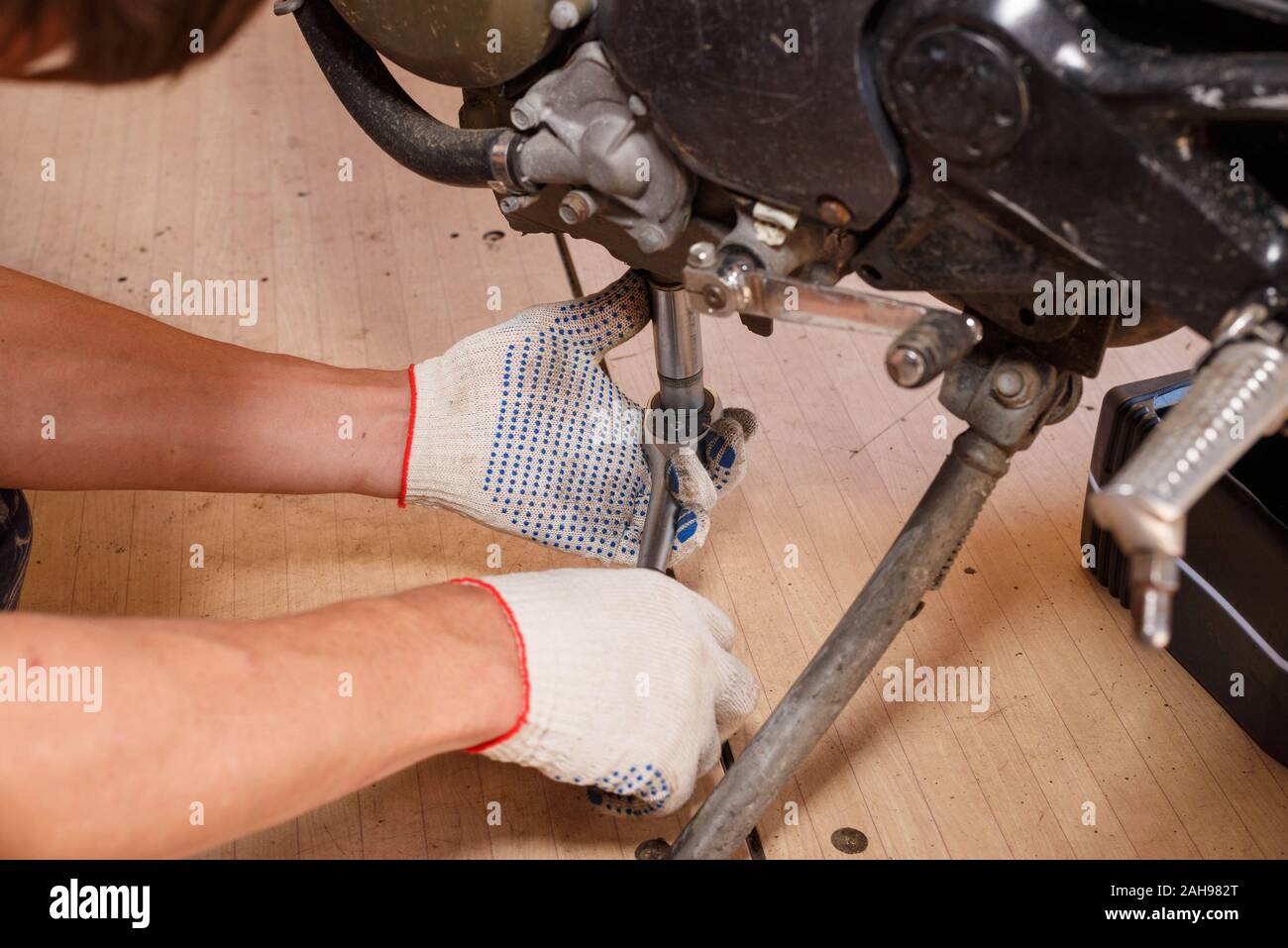 The process of draining oil from a motorcycle engine. Engine oil