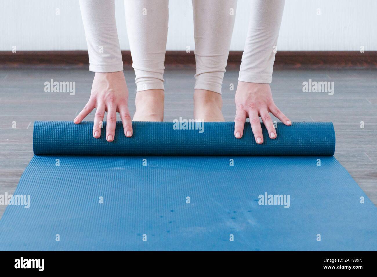 Beautiful girl getting ready for yoga indoors in daylight. Active lifestyle. Stock Photo
