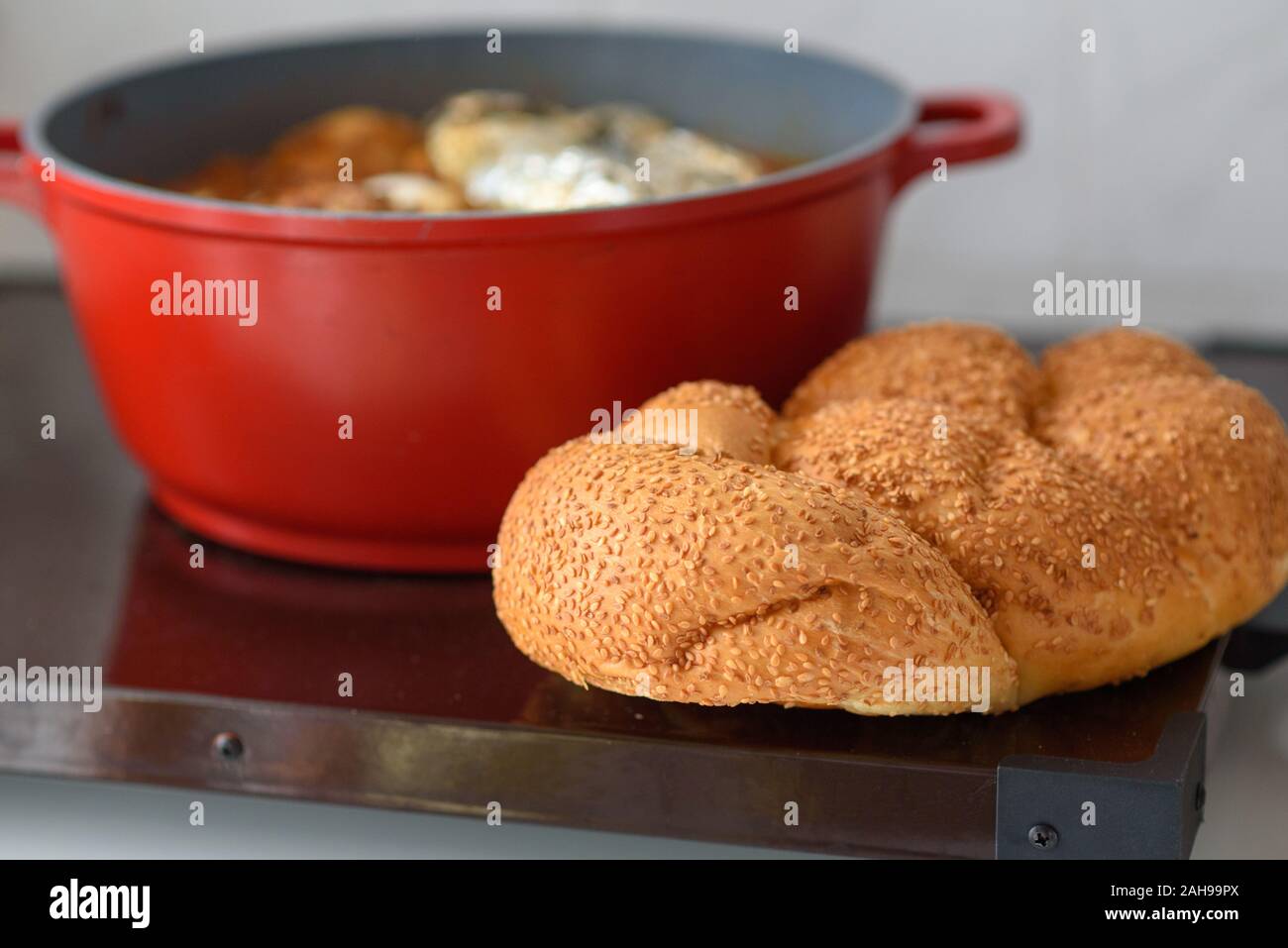 Hot plate for the Sabbath, a pot of spicy meat cooked with potatoes,  barleys, wheat and eggs. Pot of cholent Hamin in hebrew, challah-special  bread in Jewish cuisine. Traditional food Jewish Shabbat