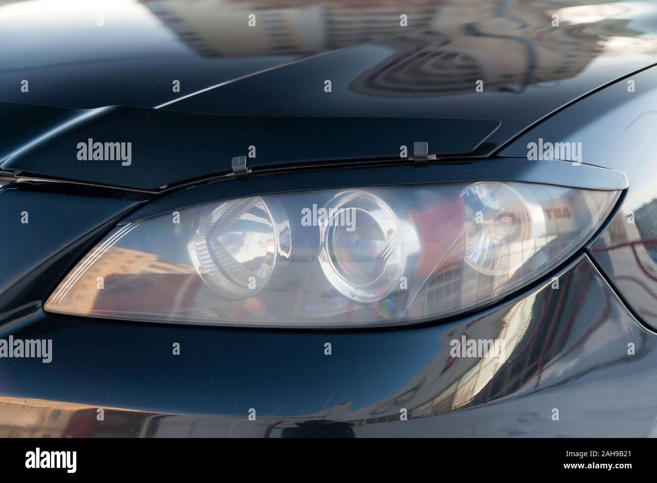 Front headlight view of car in black color after cleaning and detailing with washer before sale